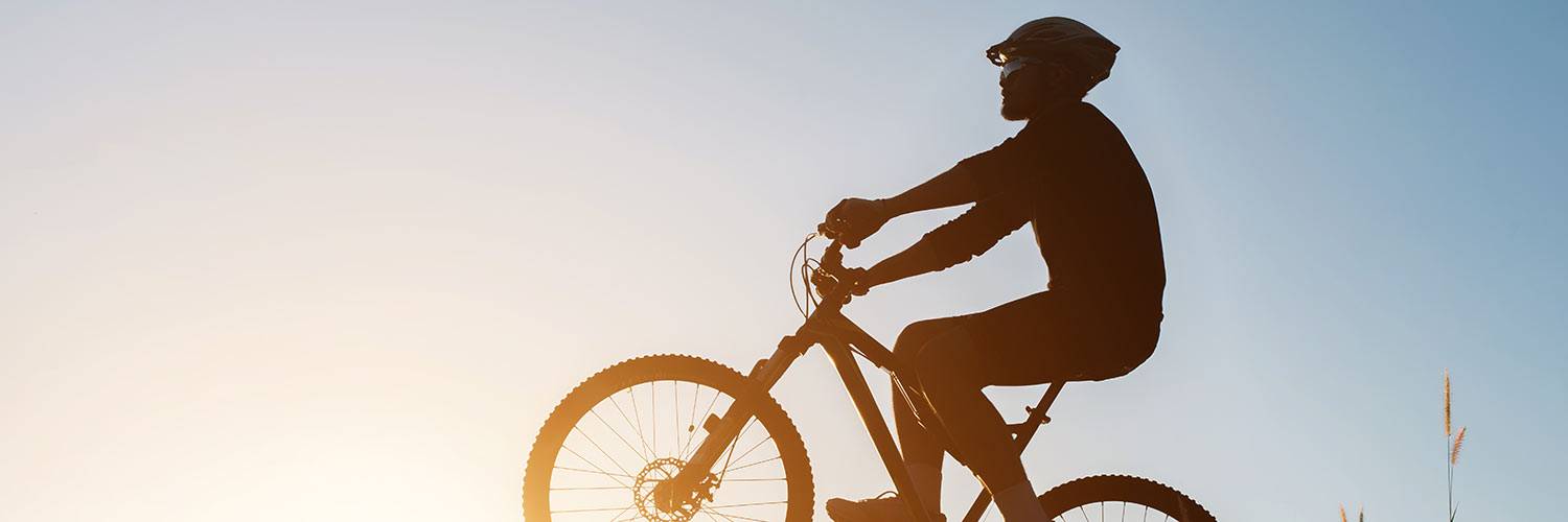 homme faisant du vtt au couché du soleil